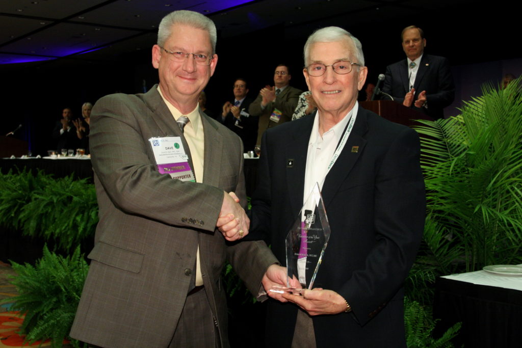 Don Bush is presented with the Volunteer of the Year Award by President Dave Hawn in 2009 for all his years of work on the RRC Exam Development Subcommittee.