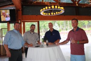 David Madonia, Paul Whitley, Charles Arnold and Kevin Burch of REI Engineers celebrate the occasion while Gary and granddaughter Julia seemingly participate in the conversation.