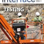Cover of the October issue of IIBEC Interface showing workers in hardhats on the side of a building representing, "Testing".