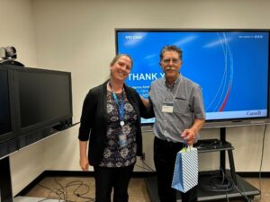 Phil Dregger, right, receives a token of appreciation from Marianne Amerston, director for climate adaptation program at the NRC. 