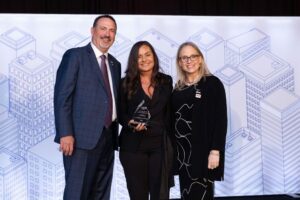 Lora (center) receives the IIBEC Outstanding Volunteer Award in 2023 from Chris Giffin (left) and Amy Peevey.