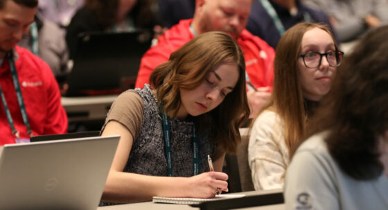 A woman takes notes during an IIBEC education session.
