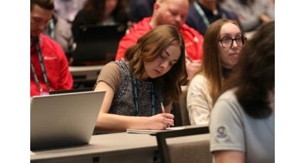 A woman takes notes during an IIBEC education session.